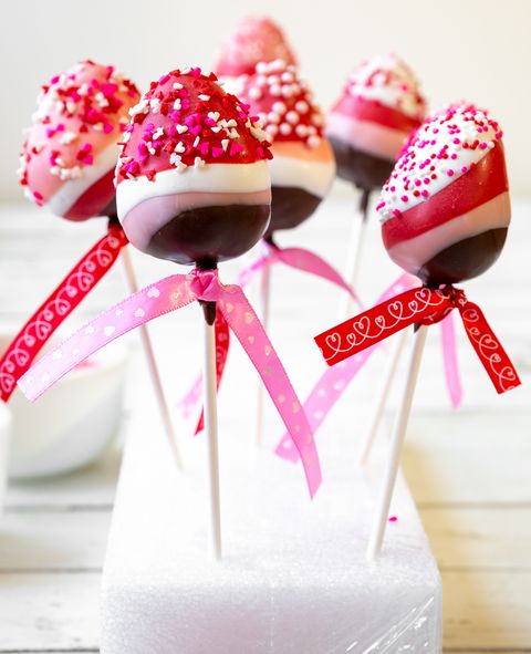 chocolate dipped strawberry pops with pink and red ribbons