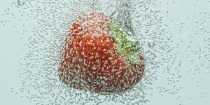 strawberry falling in fizzy water