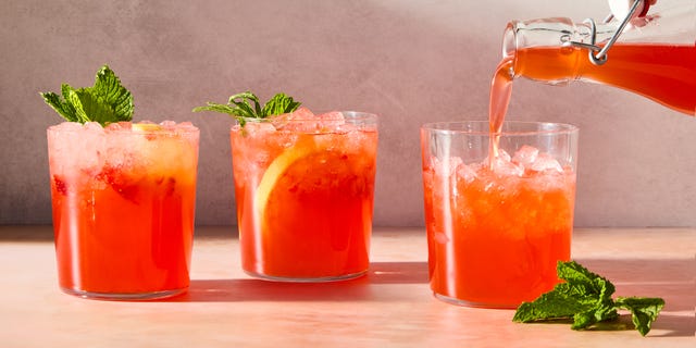 strawberry lemonade shrub with ice in a glass with mint
