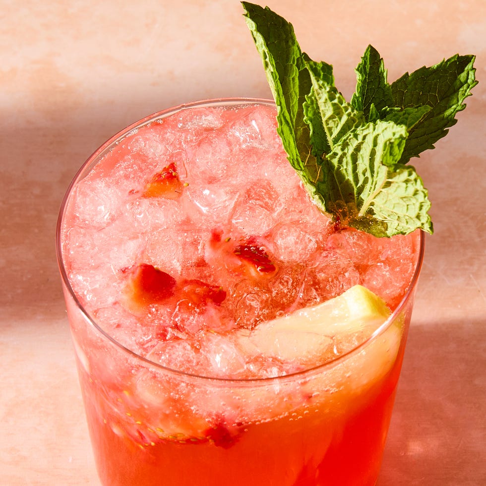 strawberry lemonade shrub with ice in a glass with mint