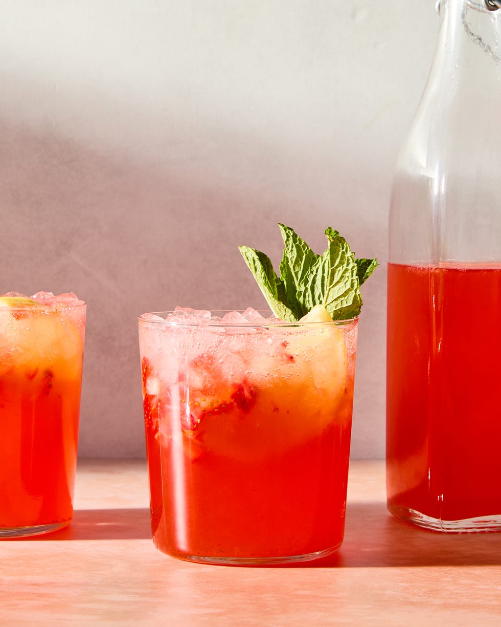 strawberry lemonade shrub with ice in a glass with mint