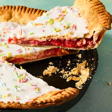 flaky pastry in a pie dish filled with strawberry filling and topped with icing and sprinkles