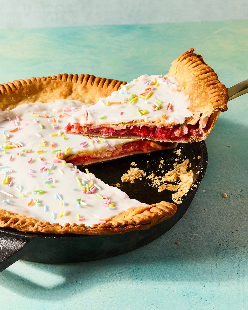 flaky pastry in a pie dish filled with strawberry filling and topped with icing and sprinkles