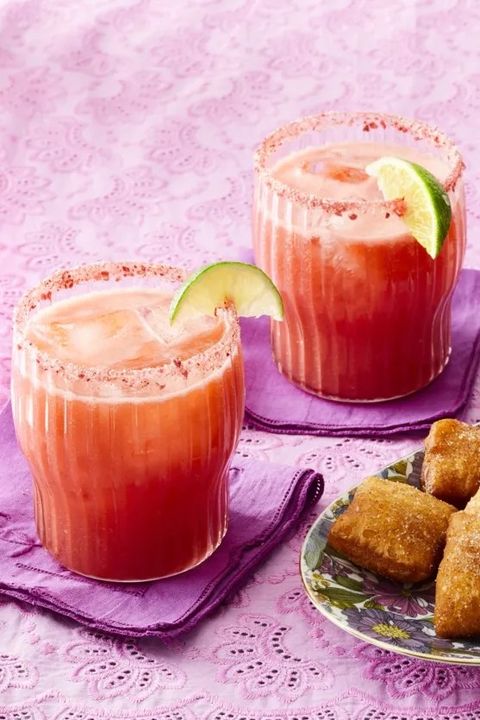 strawberry margaritas with lime wedges on purple linen napkins