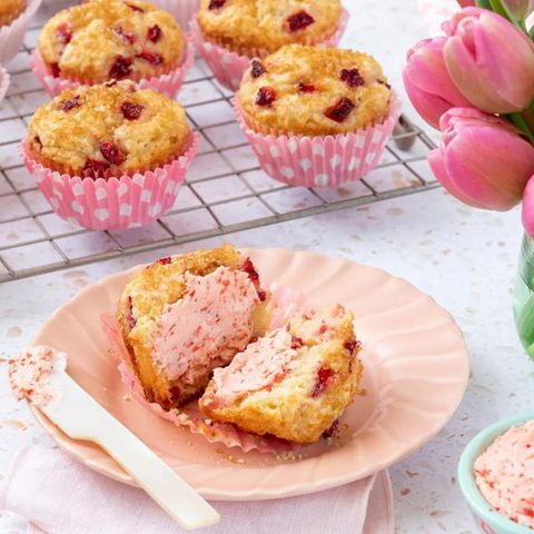 strawberry muffins on wire rack and one muffin on plate with strawberry butter
