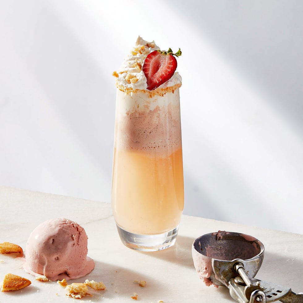 mimosa topped with strawberry ice cream, whipped cream, a strawberry slice and crushed graham crackers
