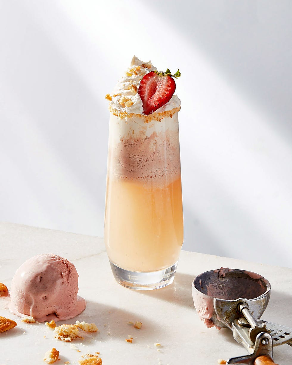 mimosa topped with strawberry ice cream, whipped cream, a strawberry slice and crushed graham crackers
