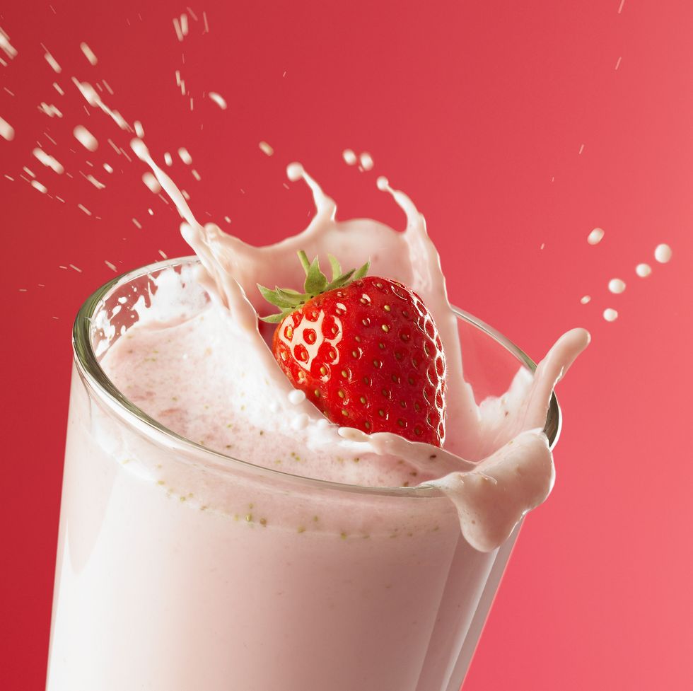strawberry splashing into smoothie
