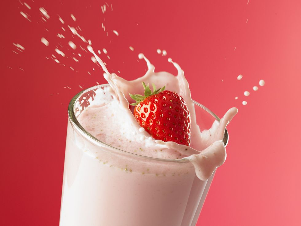 strawberry splashing into smoothie
