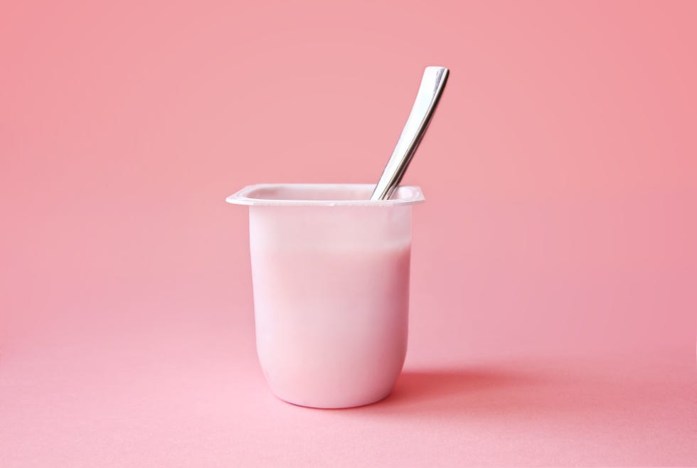 strawberry yogurt or pudding  in plastic cup on pink background