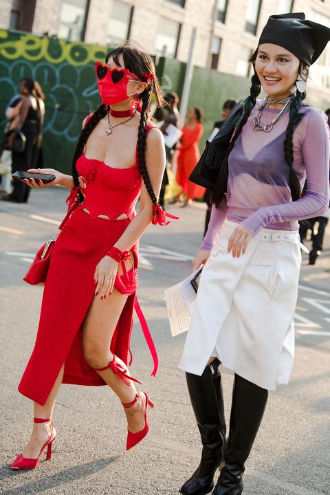 a red look and a visible bra are part of street style at new york fashion week