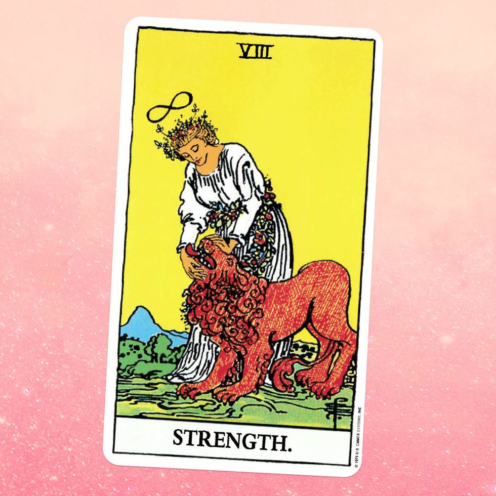the strength tarot card a woman in a white dress pets a lion