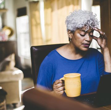stressed out woman working at laptop on table at home