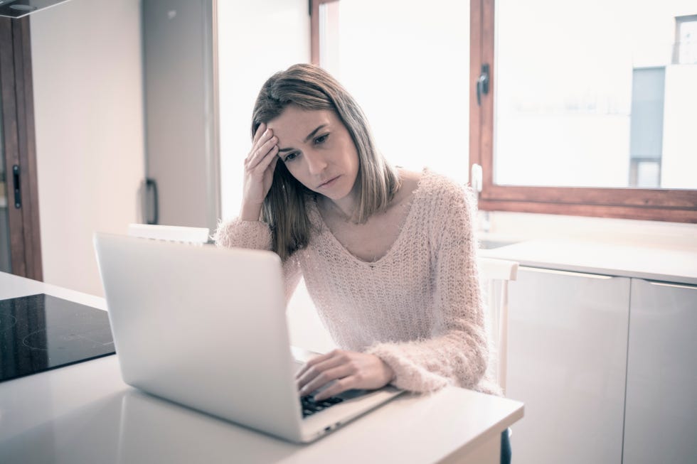 Stressed woman using laptop computer at home