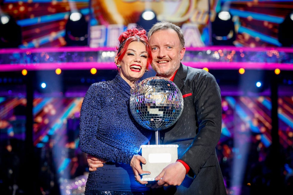 strictly's dianne buswell and chris mccausland hold the glitterball trophy