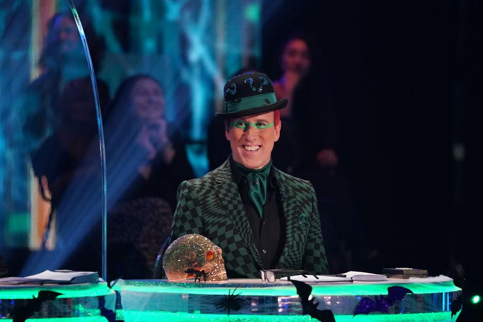 strictly come dancing judge anton du beke dressed as the riddler for halloween week, with a sparkly skull next to him on the desk