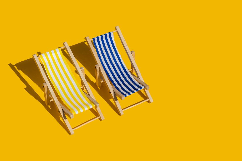 striped beach chair pattern on yellow background with copy space