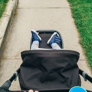 person pushing stroller with organizer hanging off handle