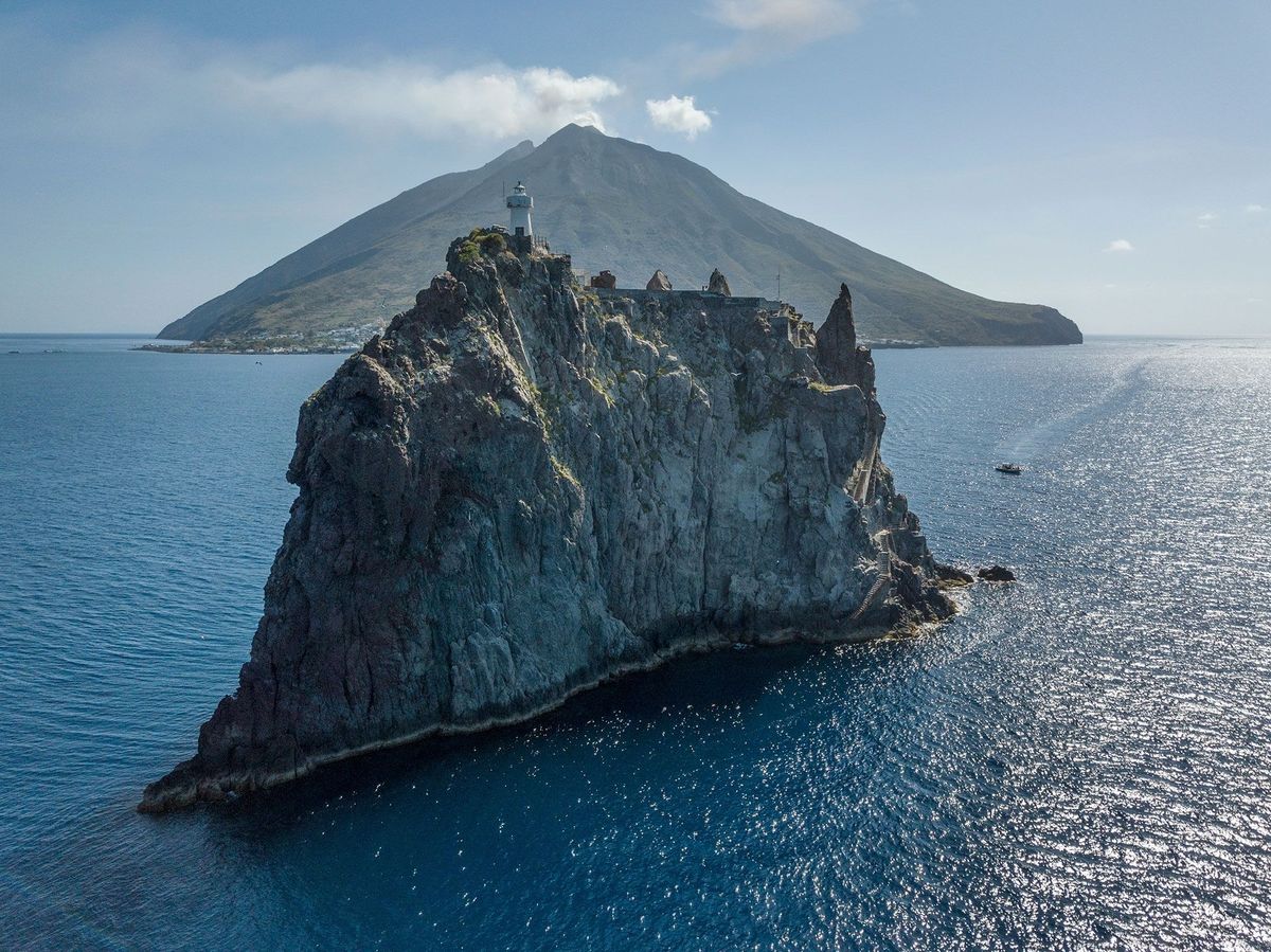 In de Tyrreense Zee verrijst het vulkaaneiland Stromboli achter zijn naburige zustereilandje Strombolicchio