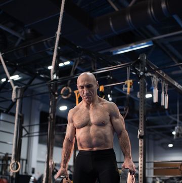 strong elderly athlete with barbell weight plates