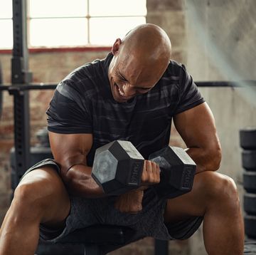 Strong man lifting weight at gym