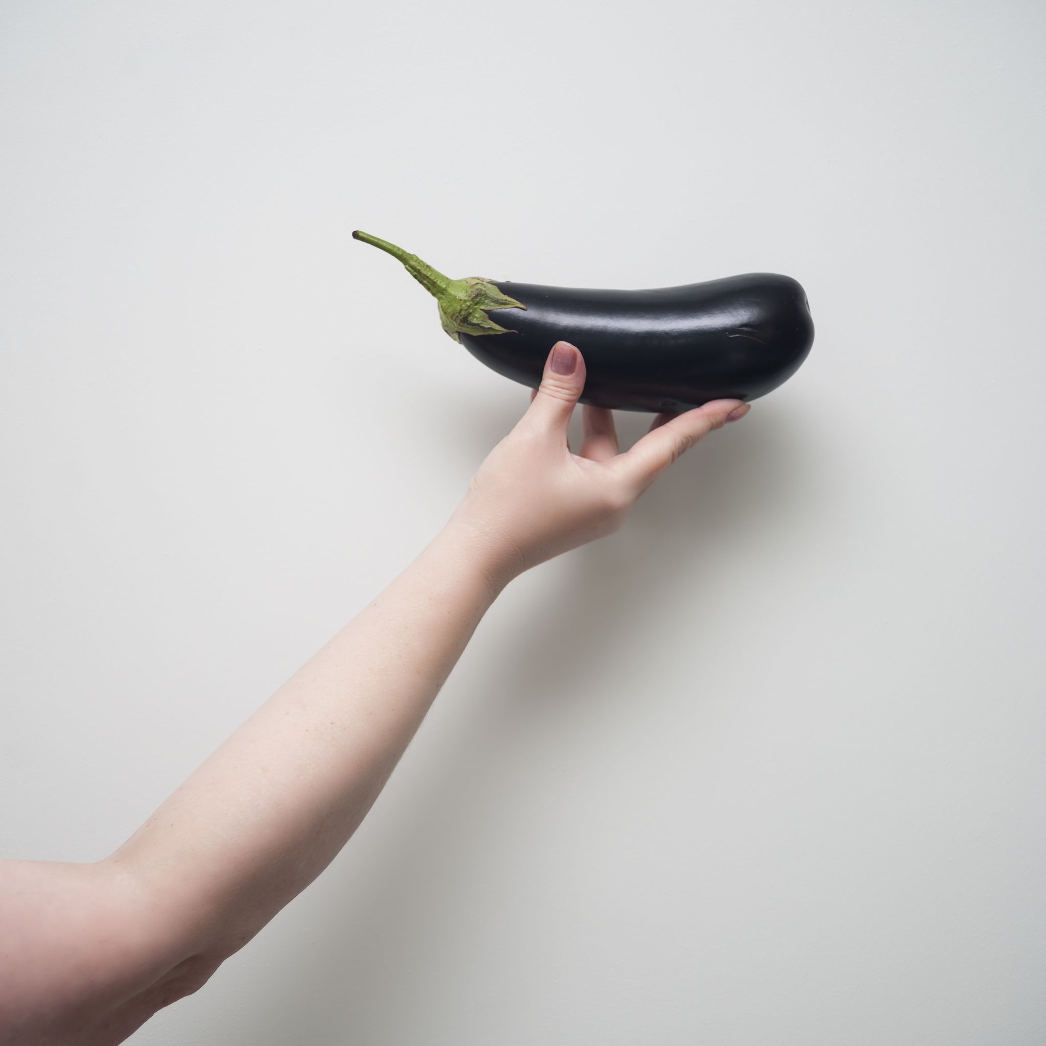Strong woman holding black eggplant