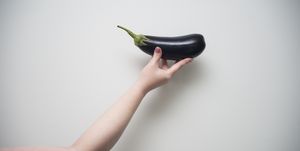 Strong woman holding black eggplant