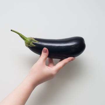 strong woman holding black eggplant