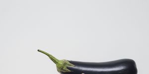 strong woman holding black eggplant