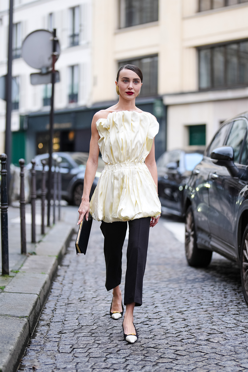 paris, france january 30: mary leest wears a light yellow sleeveless gathered top, black pants, a black leather bag, white and black leather pointed shoes, outside ashi studio, during the haute couture spring summer 2025 as part of paris fashion week on january 30, 2025 in paris, france. (photo by edward berthelot/getty images)