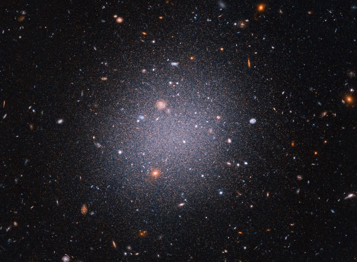 De Hubbleruimtetelescoop maakte deze opname van het vreemde sterrenstelsel DF2 dat op zon 72 miljoen lichtjaar van de aarde staat Astronomen vragen zich af hoe het kan dat DF2 geen donkere materie heeft Dit is de onzichtbare lijm die sterrenstelsels bij elkaar houdt