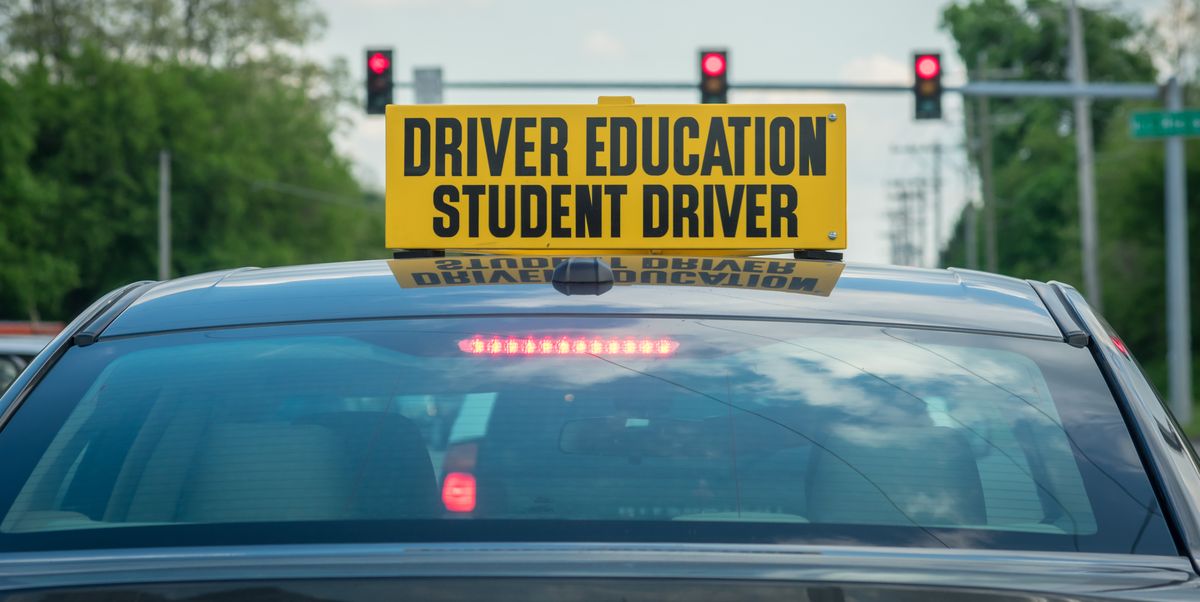 student driver sign on top of car at stoplight