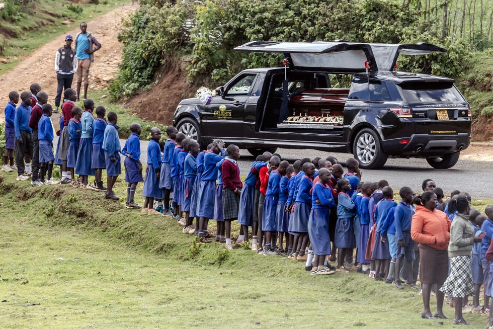 una larga hilera de niños despiden al coche funebre de kelvin ﻿kiptum