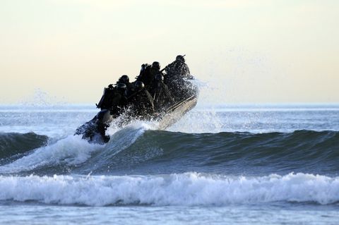 students in navy seals qualification training navigate the surf off the cost of coronado