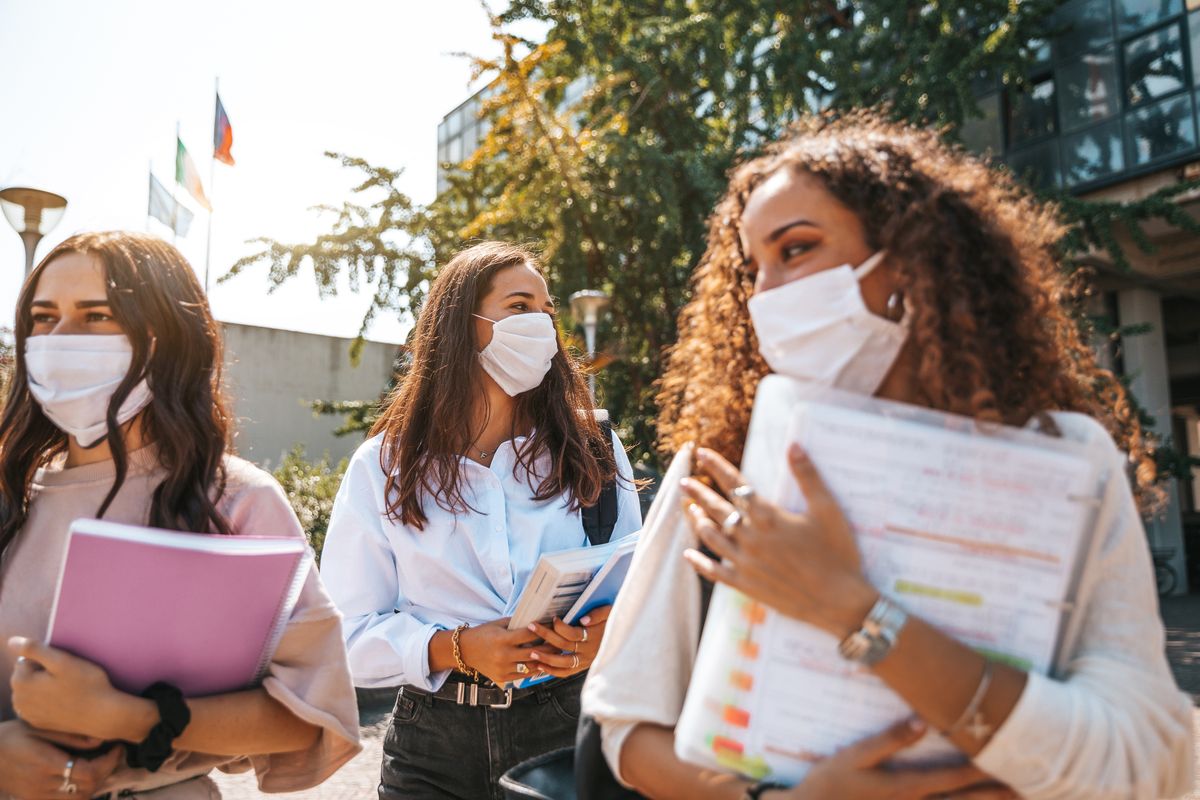 students wearing protective face masks walking out from school