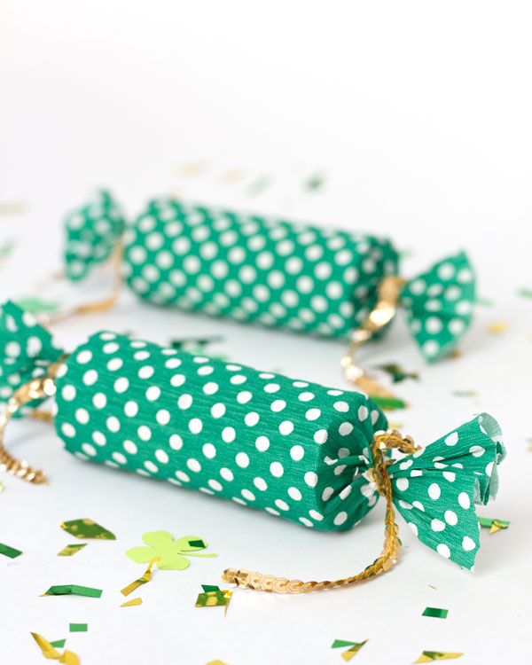 Tie the ends of two green and white polka dot party poppers together with gold sequin string.