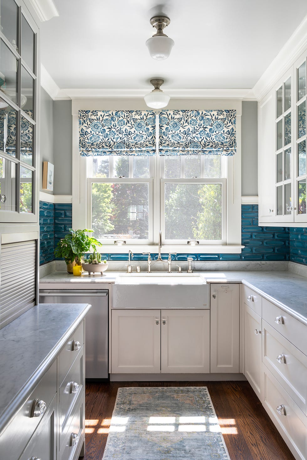 modern kitchen with a blue floral window treatment stainless steel appliances and a large sink