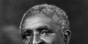 portrait photograph of george washington carver looking to his left, he wears a suit