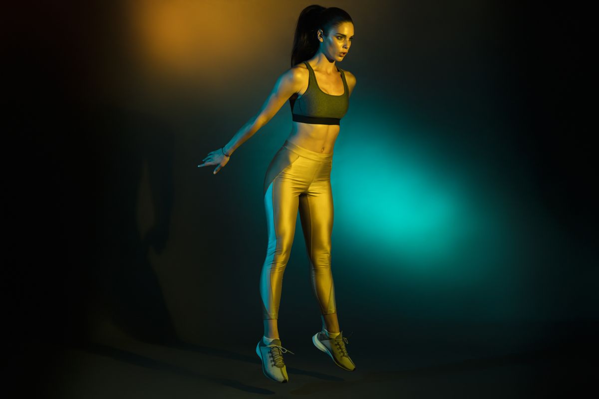 studio shot of a young sportswoman doing squat jumps