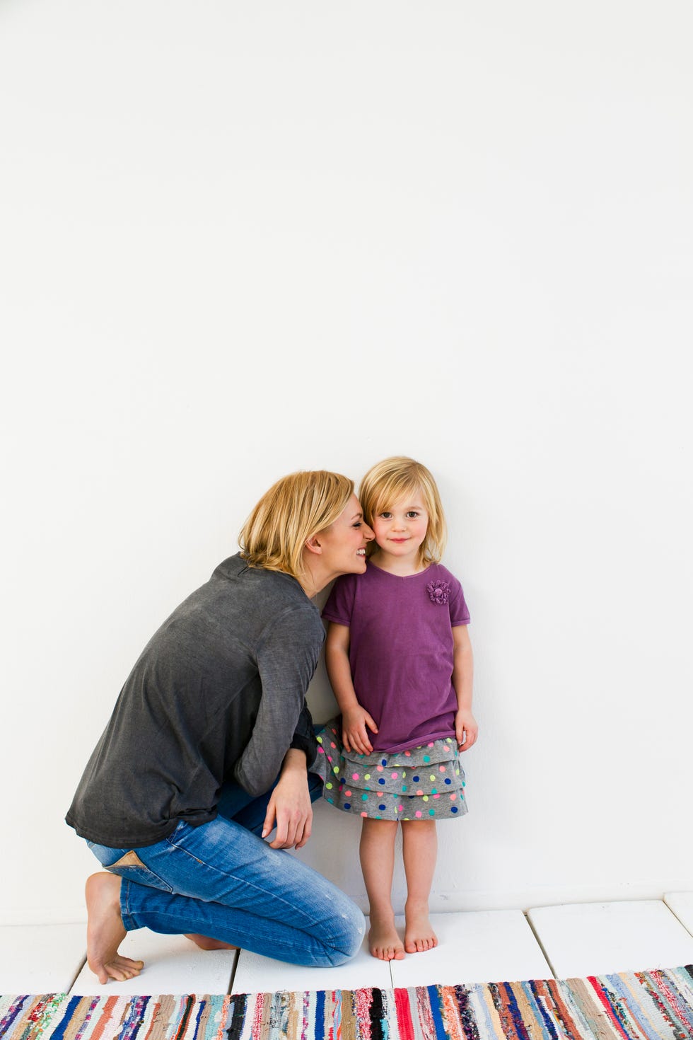 How to get the kids to school on time - Studio shot of mother kneeling next to young daughter