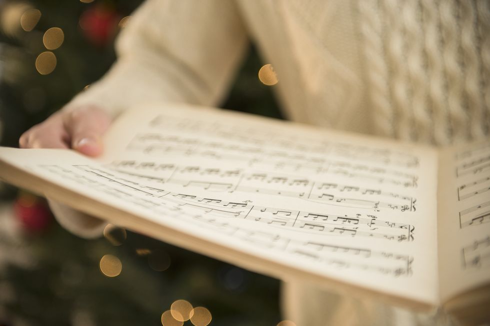 Studio Shot of woman holding sheet music at christmas