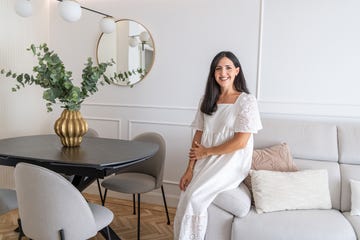 interior setting featuring a woman in a white dress modern furniture and greenery