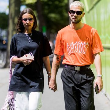 stylish couple holding hands and walking down the street