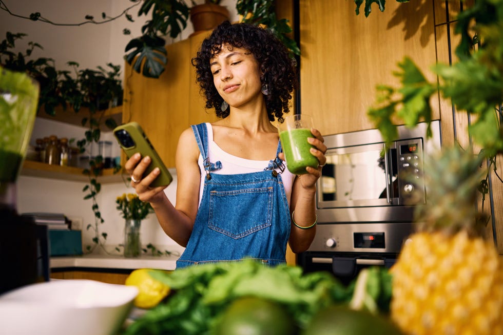 stylish home chef researches vitamin rich recipes on mobile for balanced nutrition plan