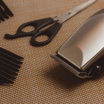 stylish professional hair clippers, accessories on brown background