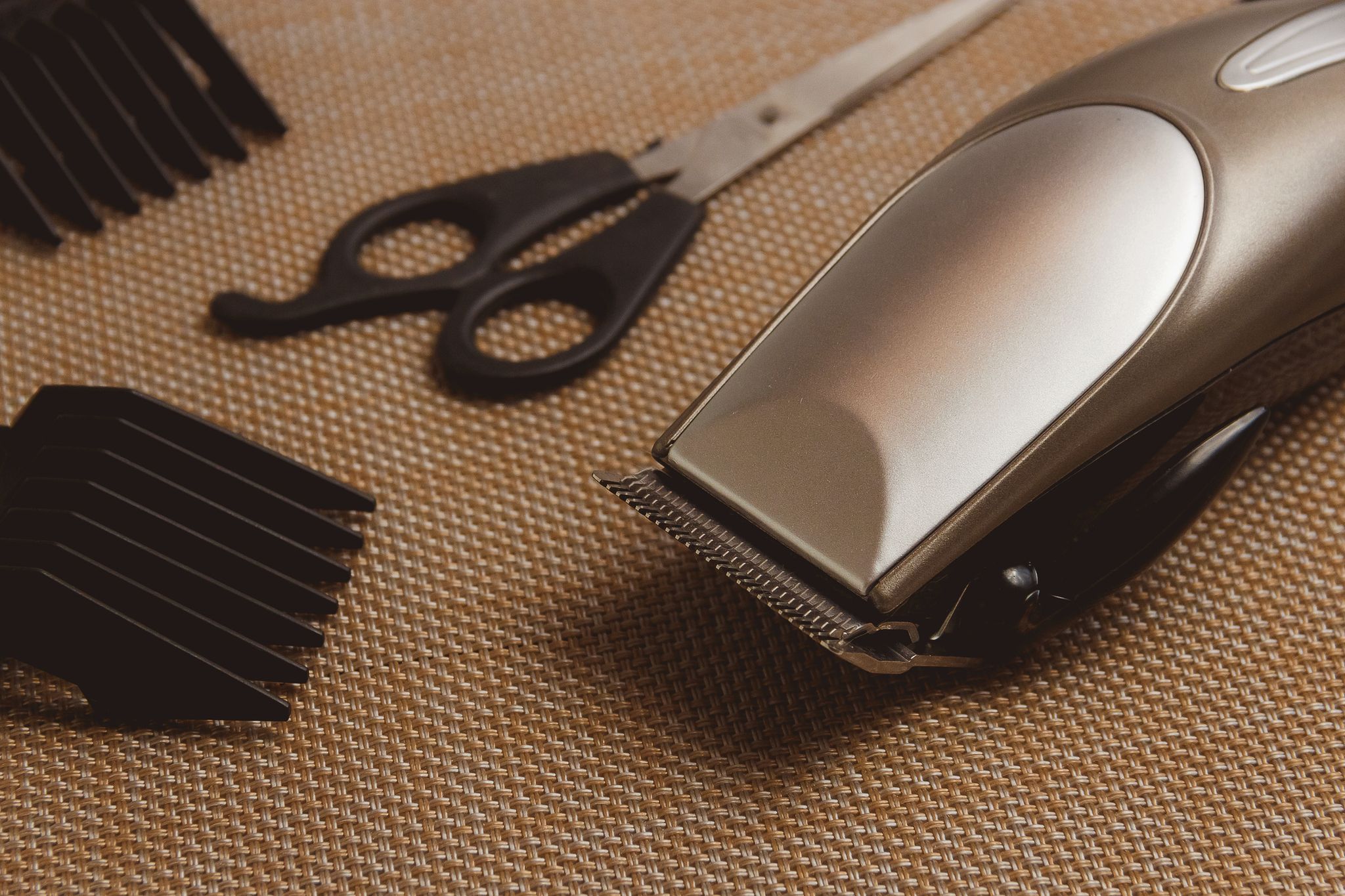 stylish professional hair clippers, accessories on brown background