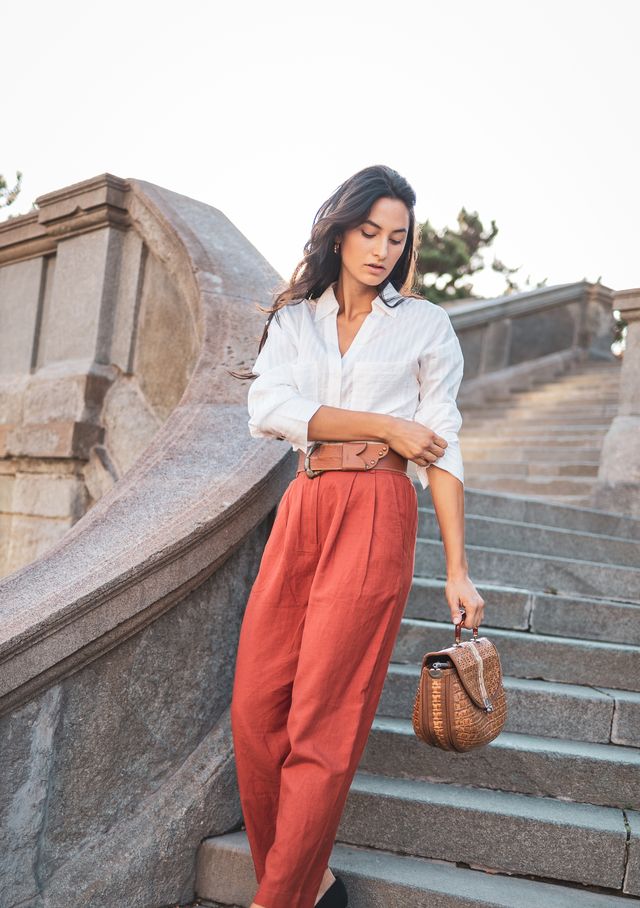 stylish woman walking down stone staircase in elegant outfit