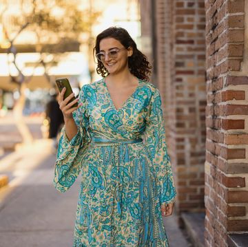 stylish woman walking down the street using smartphone