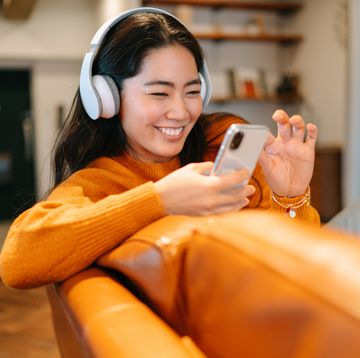 young woman listening to her headphones at home