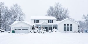 suburban colonial home during extreme blizzard snow storm